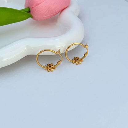 Gold-tone mini hoop earrings with logo charm, pair shown at angle
