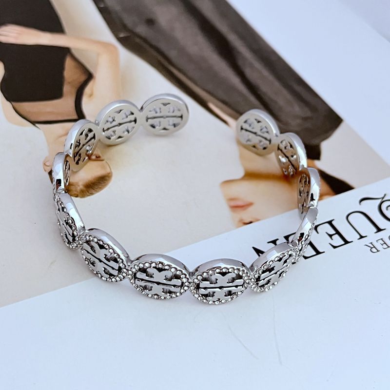 White-gold openwork logo bangle with diamond-studded circular links