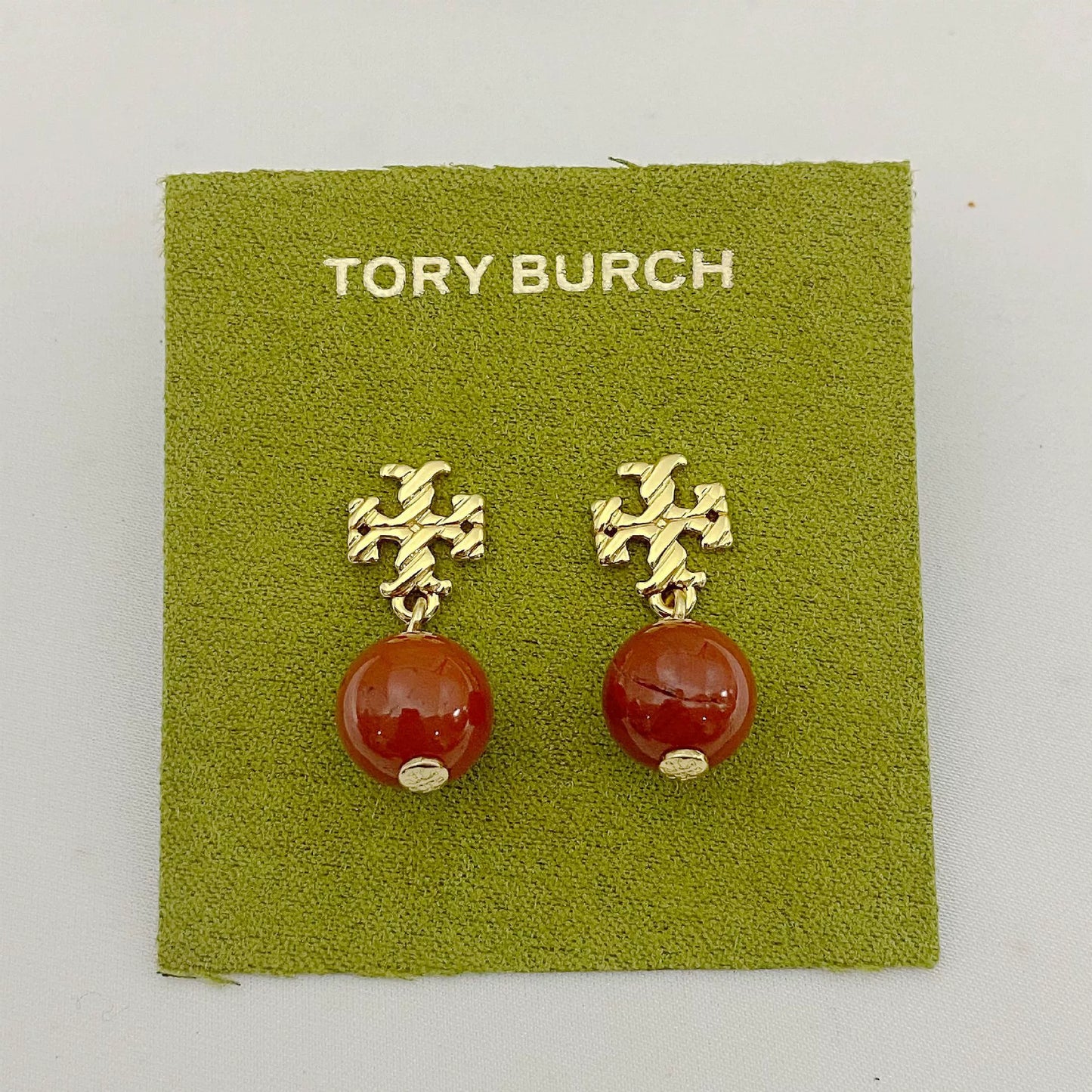 Gold-tone agate pendant earrings with round orange-red stones and leaf-like top