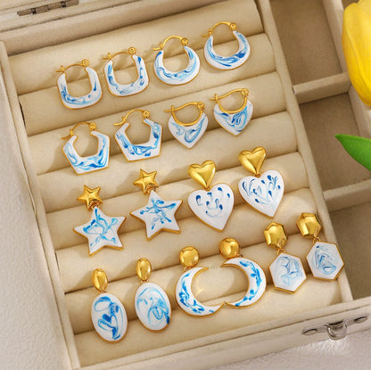Jewelry tray of blue marble gold-tone earrings, including hoops, stars, and drops