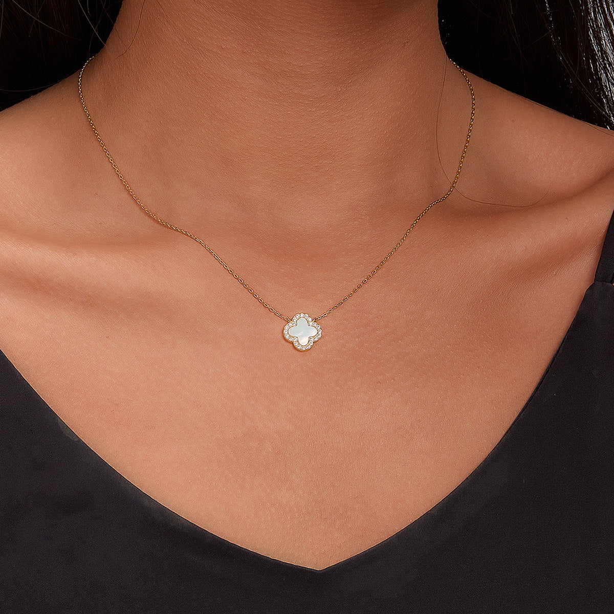 Clover mother-of-pearl pendant necklace on model neckline with gold-tone chain