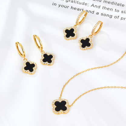 Gold-tone four-leaf clover pendant necklace with black onyx center and clear stones