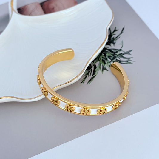 Enamel logo open metal bangle, white with gold-tone patterned trim