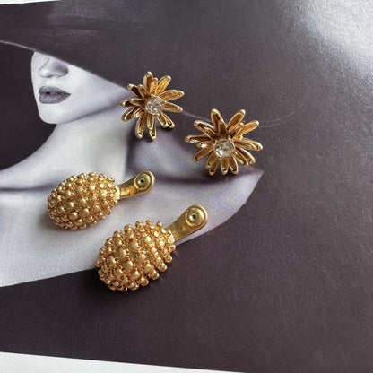 Gold pineapple drop earrings with enamel flower tops and clear stone centers.