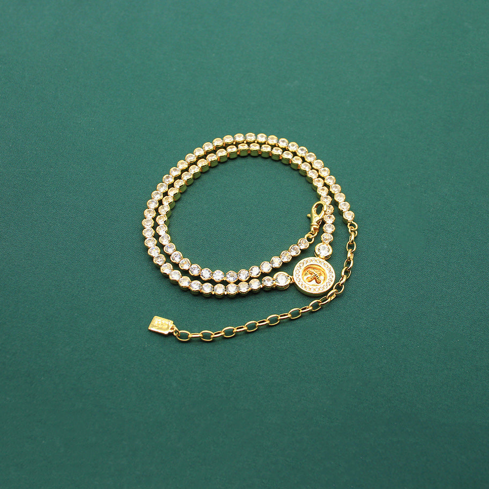 Gold-tone beaded bracelet with round coin clover charm and extension chain