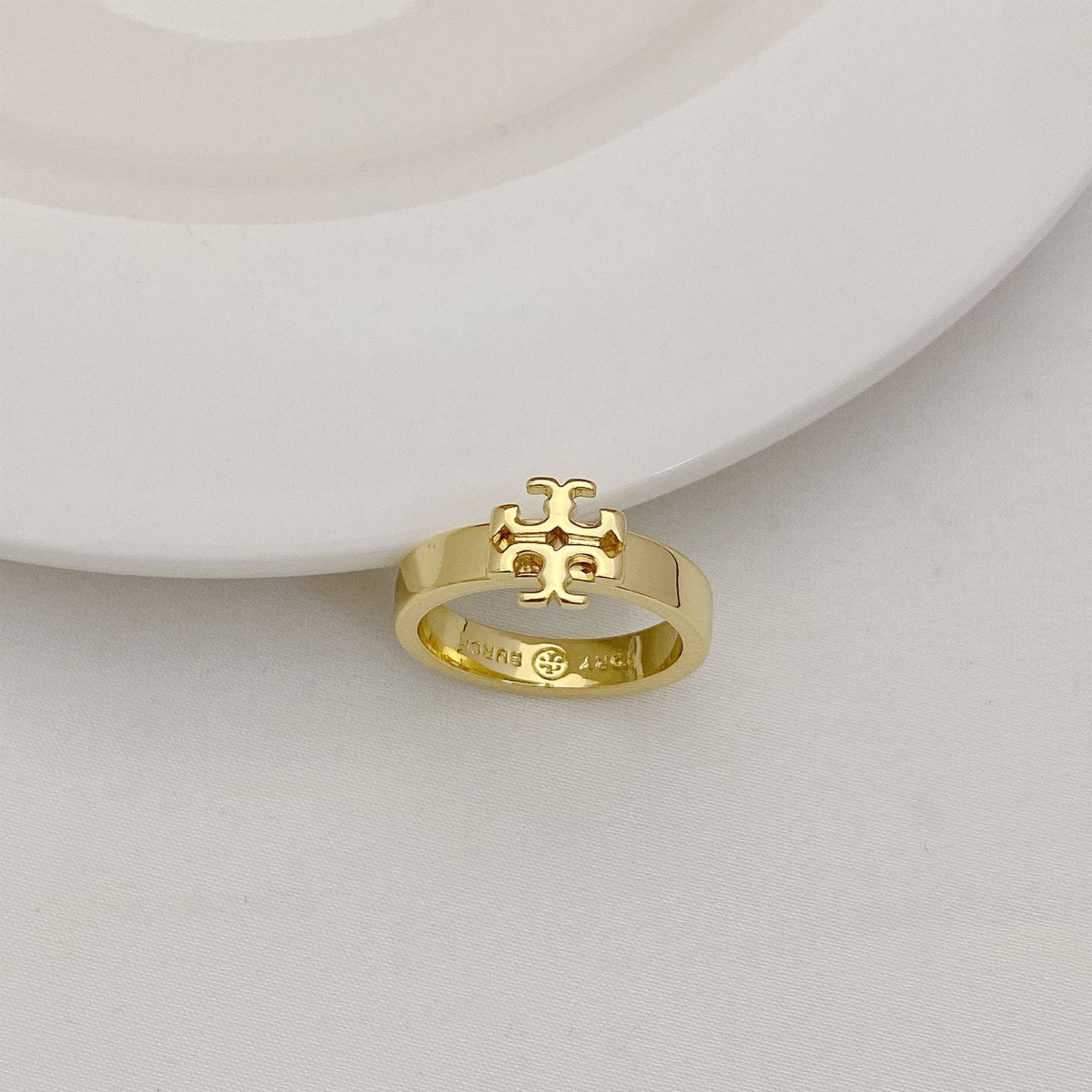 Gold-tone geometric letter-style ring with raised lattice emblem on top