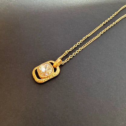 Gold-tone hammered square pendant necklace with clear faceted gemstone on chain