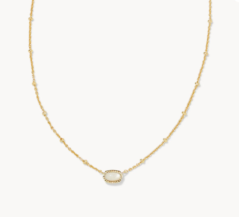 Gold-tone necklace with small oval white gemstone pendant on a fine chain.