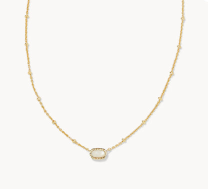 Gold-tone necklace with small oval white gemstone pendant on a fine chain.