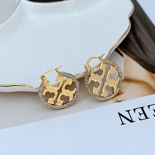 Tory Burch rhinestone openwork metal hoop earrings, gold-tone with four-petal cutouts
