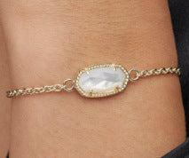 Gold-tone adjustable bracelet with oval crystal center and link chain