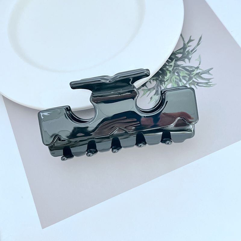 T-shaped shark hair clip in dark glossy resin with black prongs