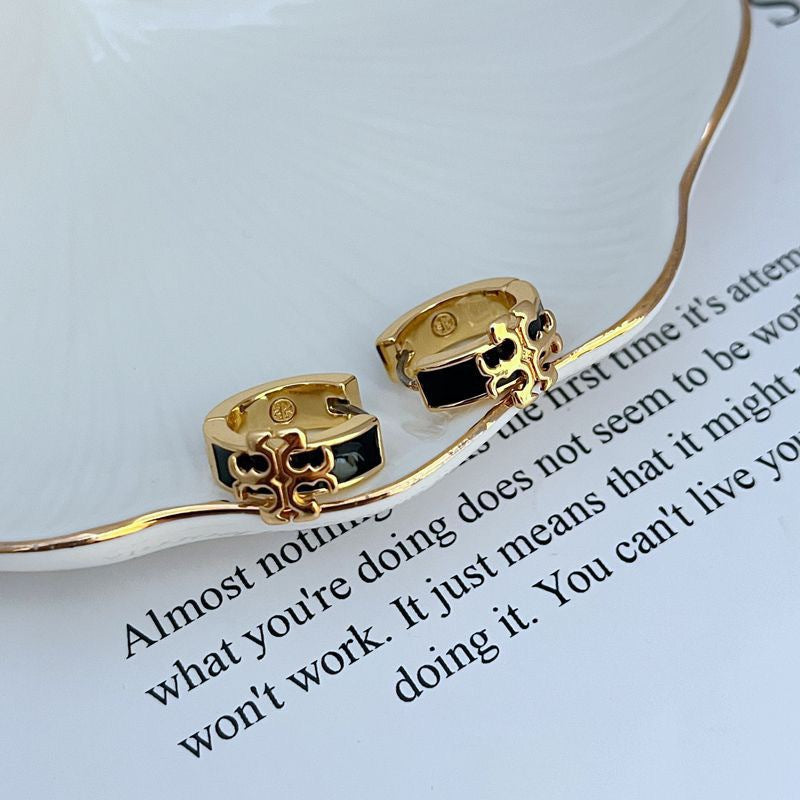 Enamel logo metal earrings with black and gold-tone detailing, hoop style
