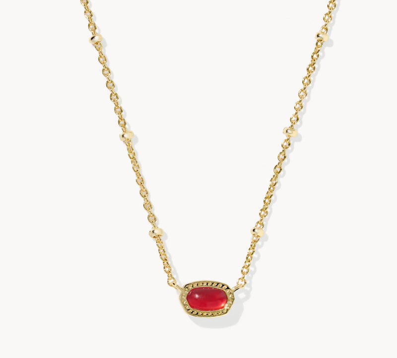 Gold-tone necklace with oval red gemstone pendant on a fine chain.