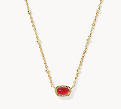 Gold-tone necklace with oval red gemstone pendant on a fine chain.