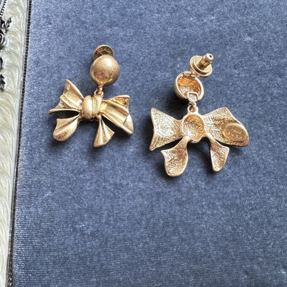 Gold-tone vintage metal bow earrings shown from front and back, with round ball posts.