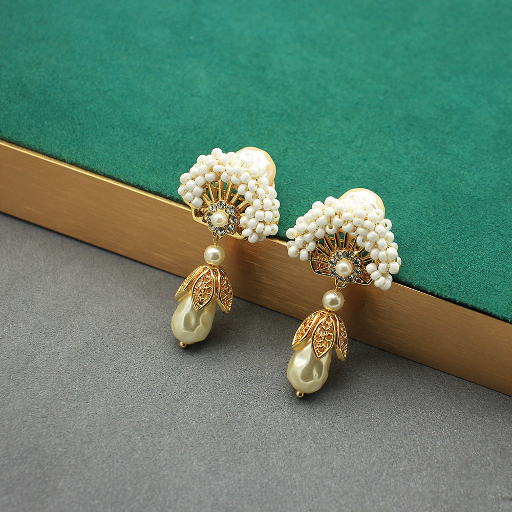 Fan-shaped pearl earrings with gold accents and dangling teardrop pearl drops, stud style