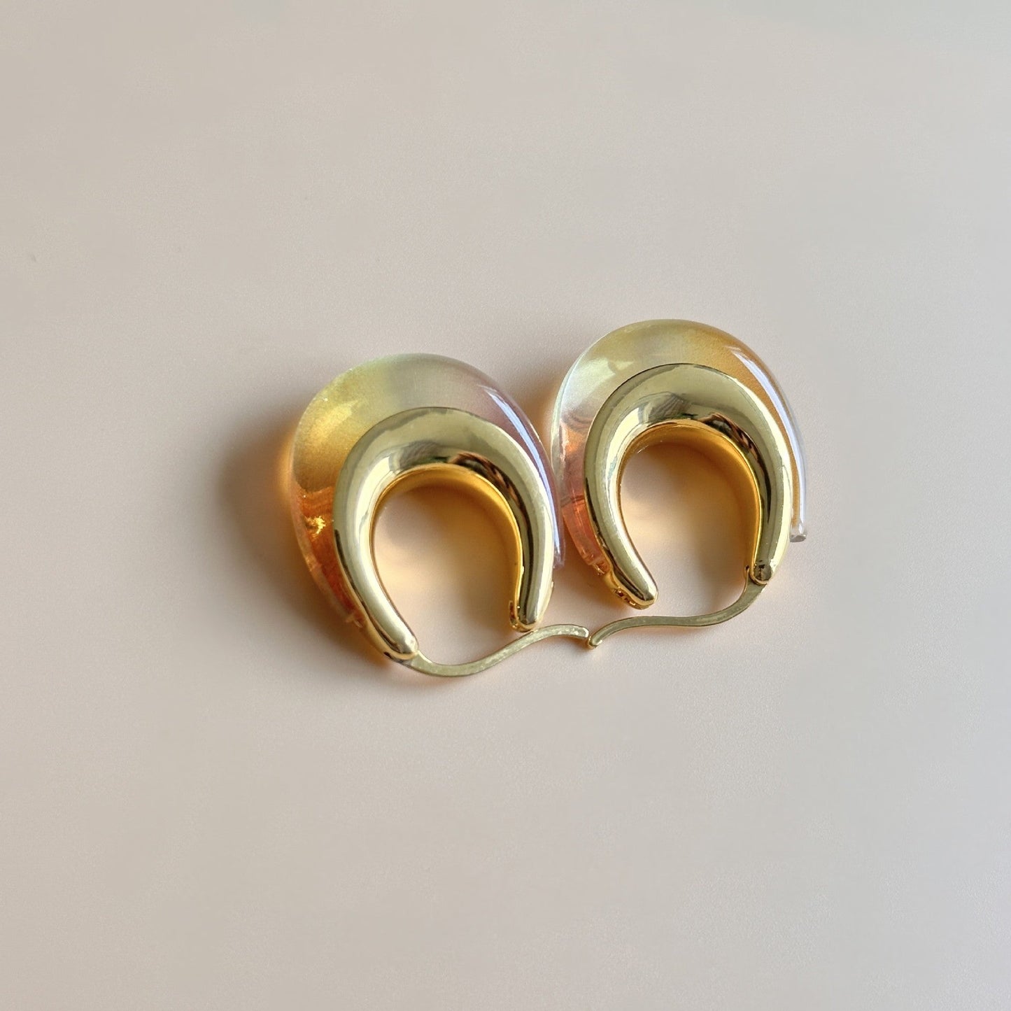 Ombré U-shaped hoop earrings with gold-tone edges; pale yellow to amber resin gradient