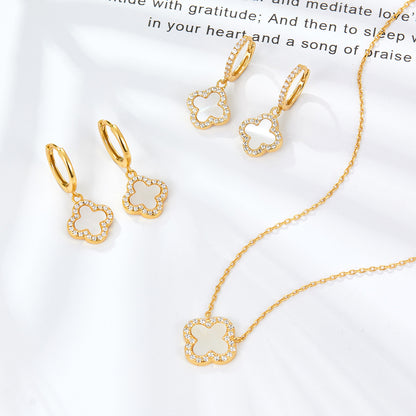 Gold-tone clover hoop earrings with white enamel charm and rhinestone trim