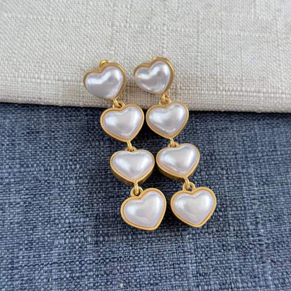 Heart-shaped long drop earrings with white pearl hearts and gold-tone links