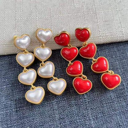 Heart-shaped long drop earrings with red and white pearl hearts and gold-tone links