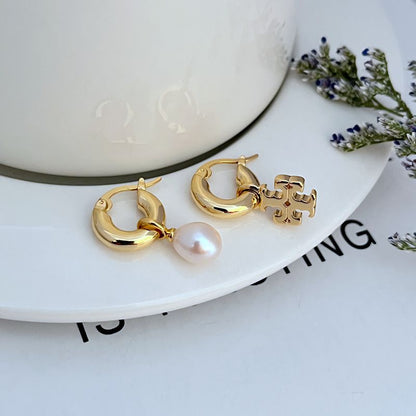 Gold asymmetrical pearl hoop earrings with dangling white pearl and charm detail