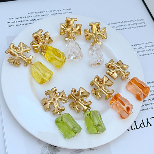 Gold-tone logo pendant earrings with multicolor acrylic drop charms (clear, yellow, orange)