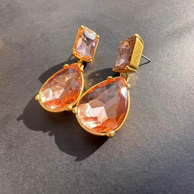 Gold teardrop-cut stud earrings with peach-orange teardrop and square stones