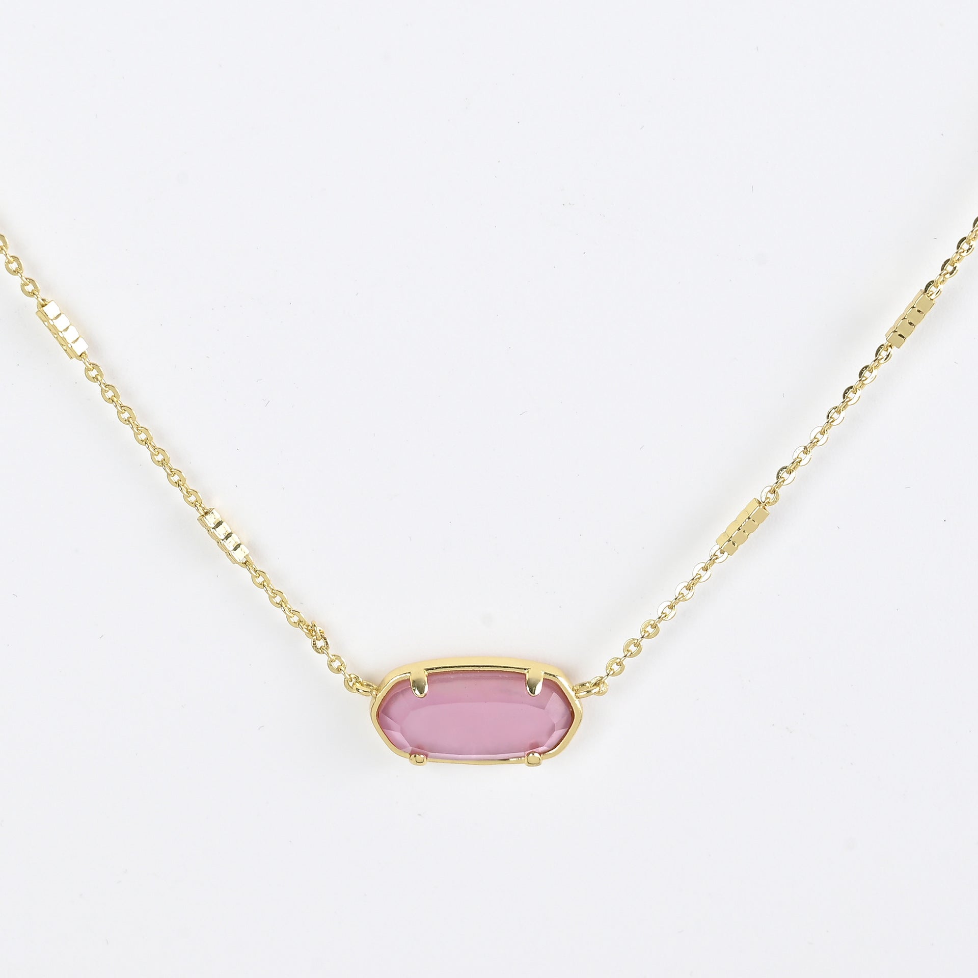 Oval crystal pendant necklace with rose pink stone and gold bezel on a gold chain