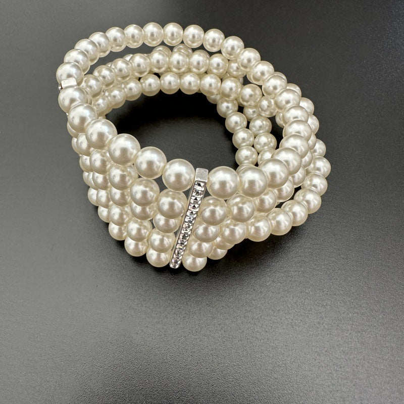 Multi-row faux pearl bracelet with small rhinestone bar clasp across the center