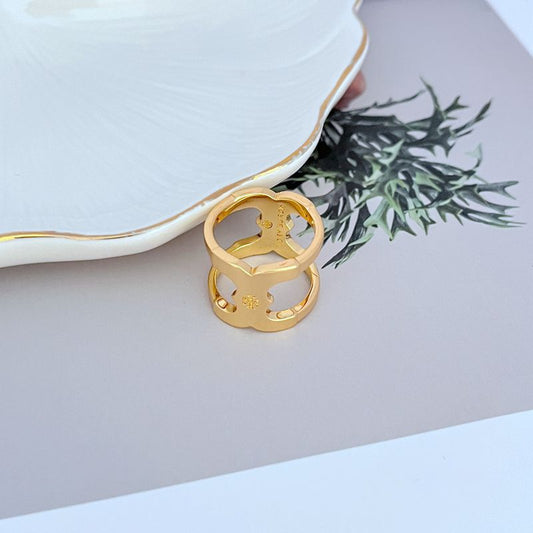 Gold wide polished metal ring with sculpted cutout motifs