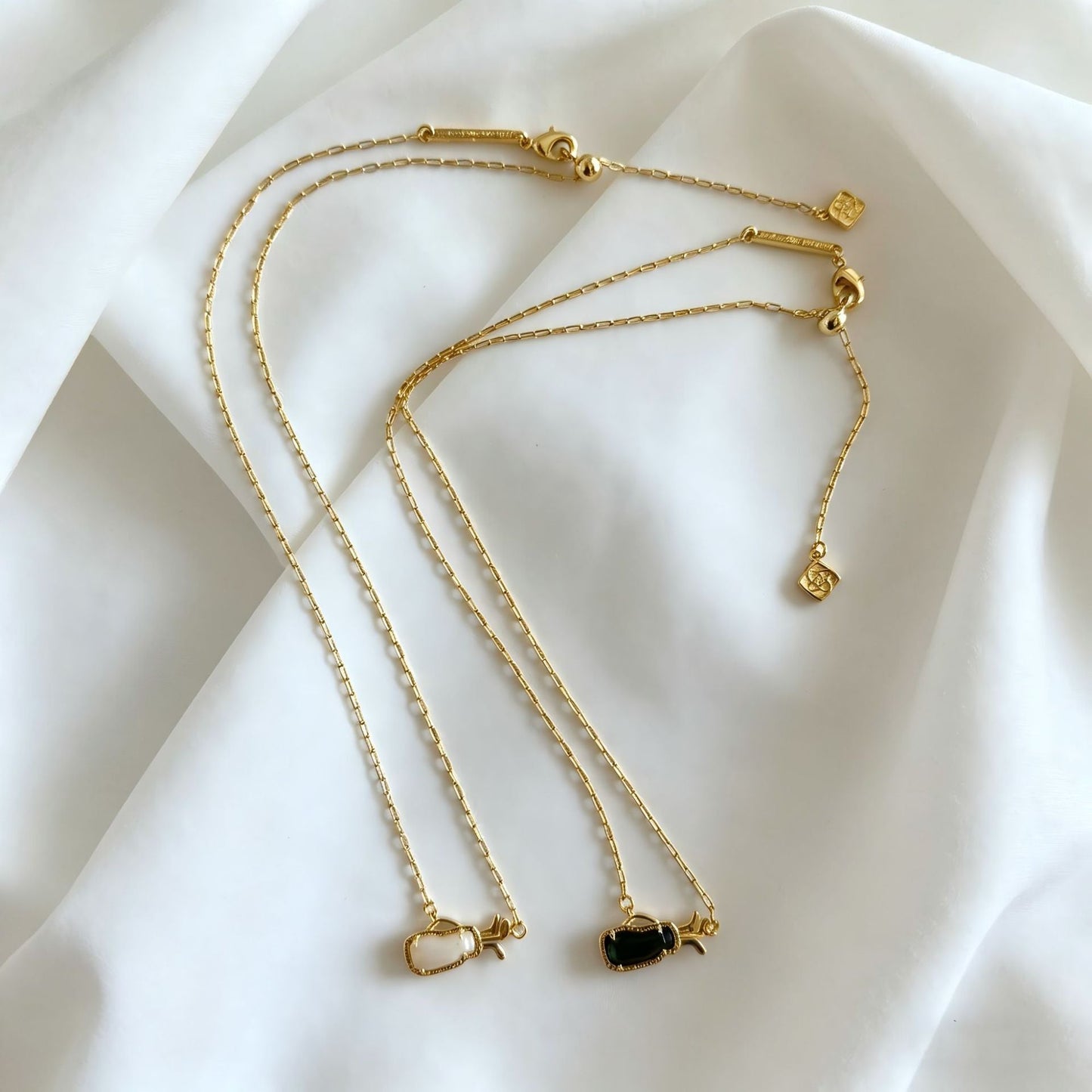 Gold-tone layered charm necklace with multiple thin chains and small heart pendants