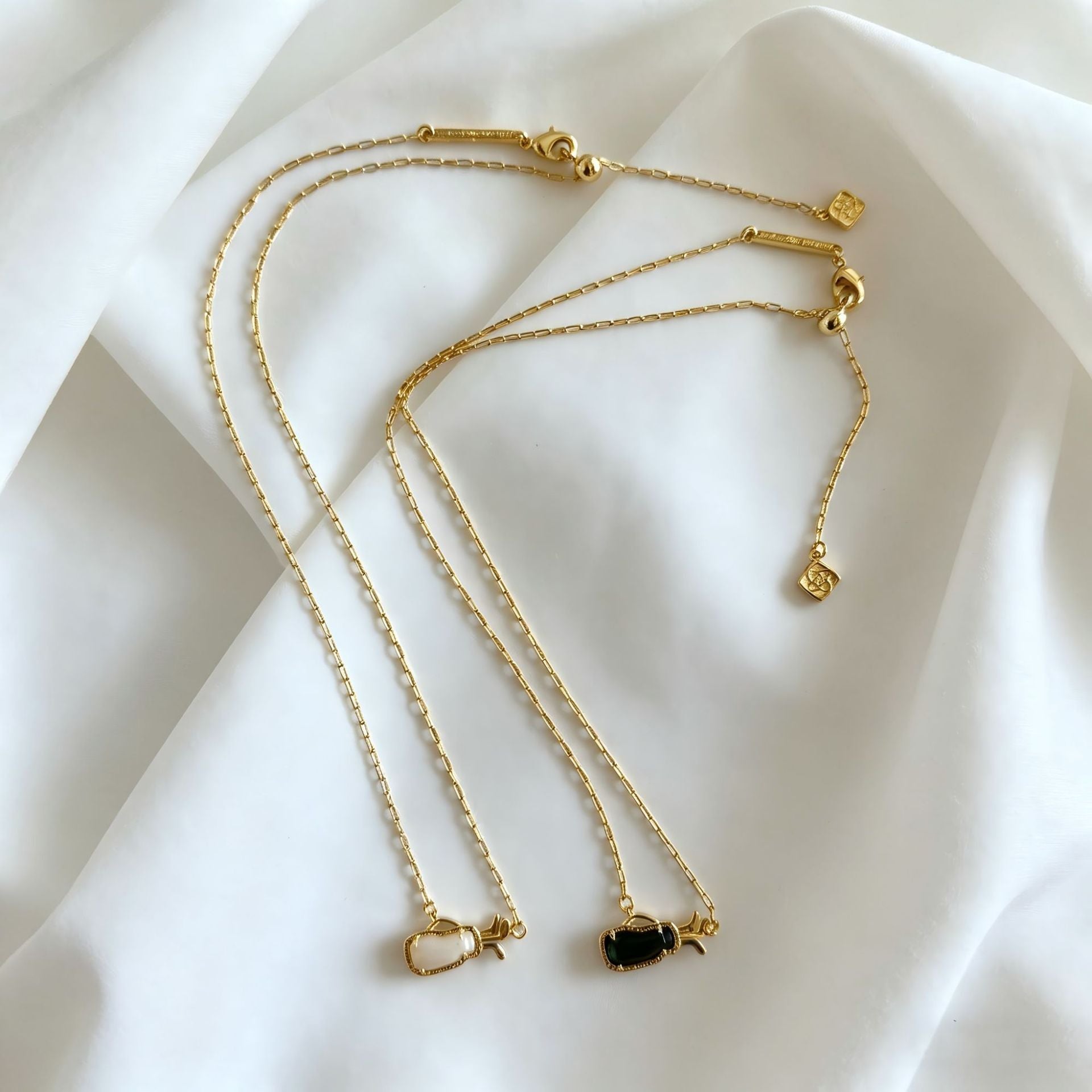 Gold-tone layered charm necklace with multiple thin chains and small heart pendants