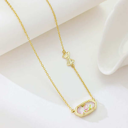 Gold butterfly pendant necklace with oval pink enamel pendant and butterfly charm