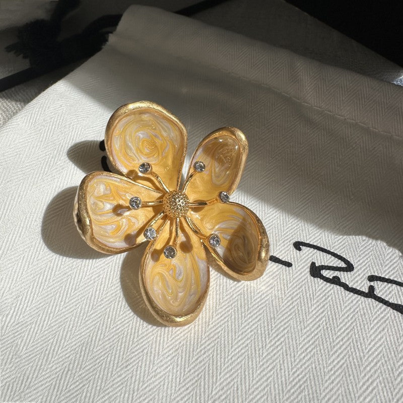 Pale yellow enamel cherry blossom metal brooch with curved petals and rhinestones