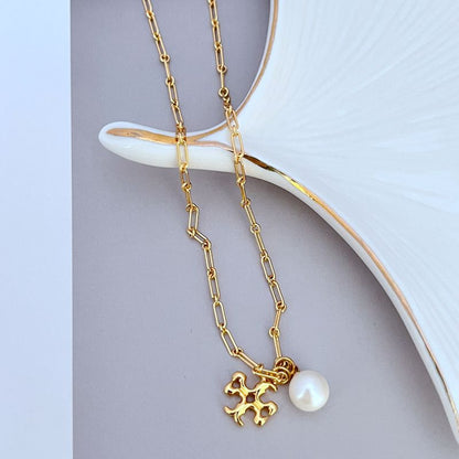 Gold-tone logo charm and round white pearl drop on a linked chain necklace