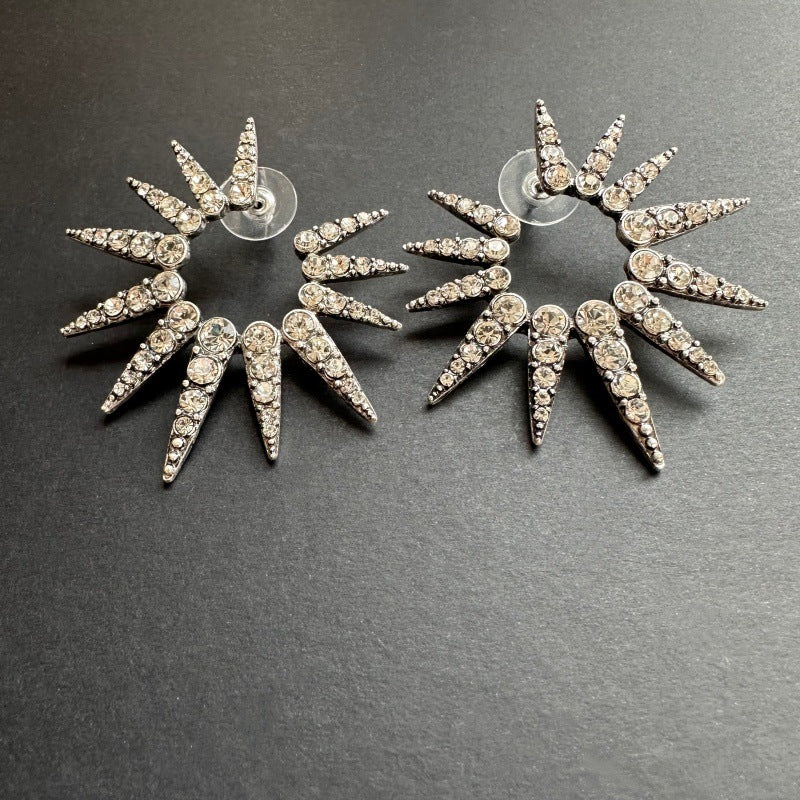 Silver-tone starburst stud earrings with faceted clear rhinestones