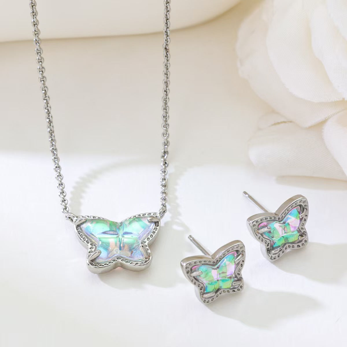 Silver butterfly pendant necklace with iridescent stones and matching stud earrings