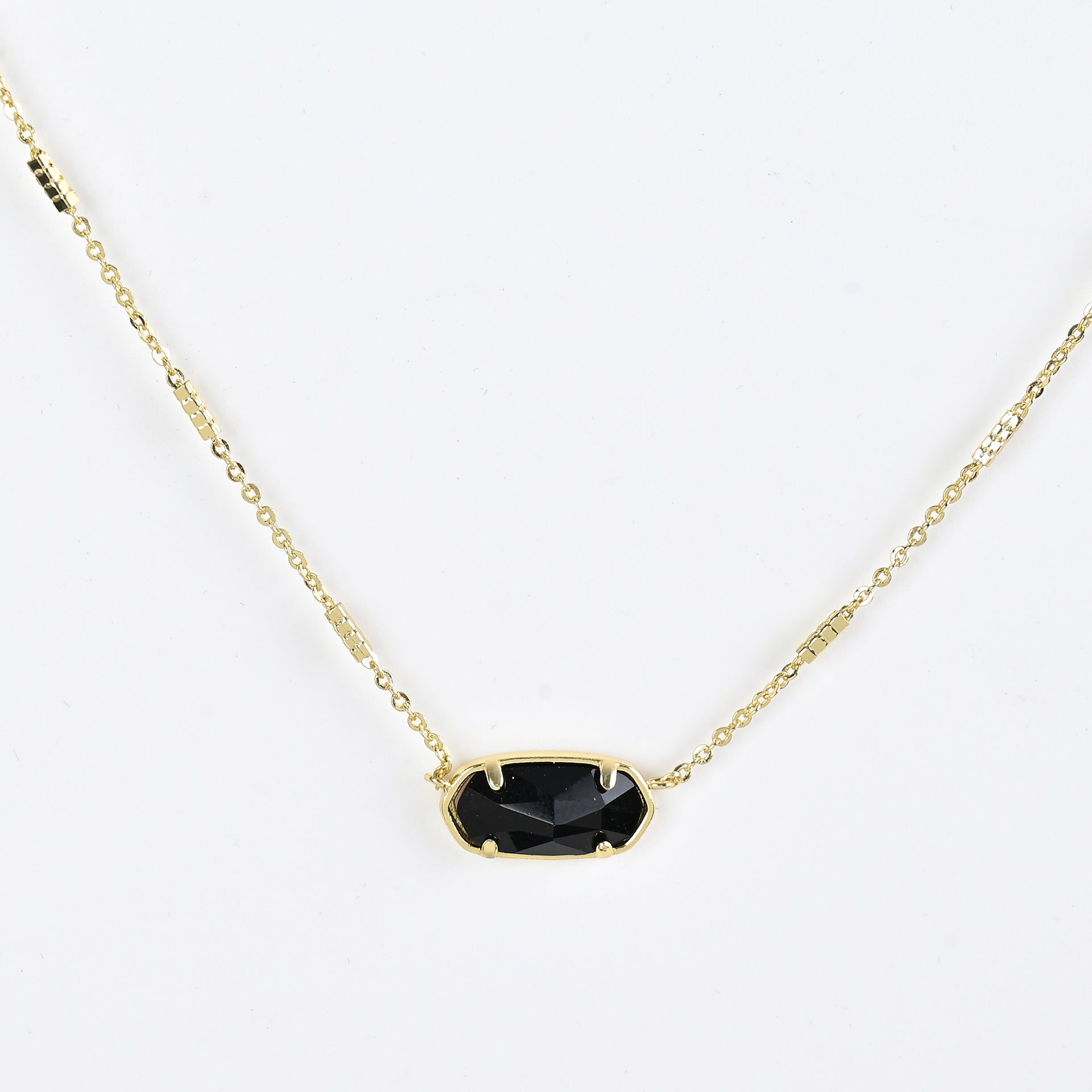 Oval crystal pendant necklace with black stone and gold bezel on a gold chain