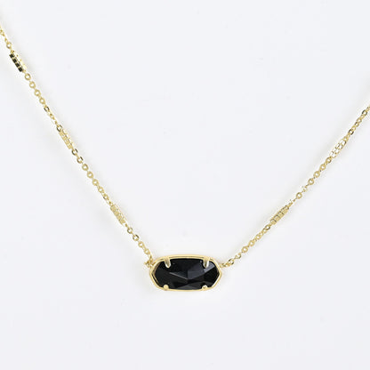 Oval crystal pendant necklace with black stone and gold bezel on a gold chain