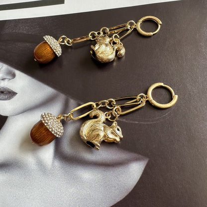 Gold-tone squirrel earrings with orange acorn bead, rhinestone cap, and hoop clasp
