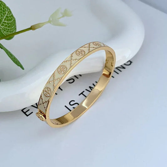 Women’s open enamel metal bracelet, gold-tone with pinkish patterned band and hinge clasp
