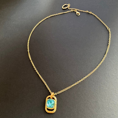Gold chain square pendant necklace with hammered texture and blue faceted gem