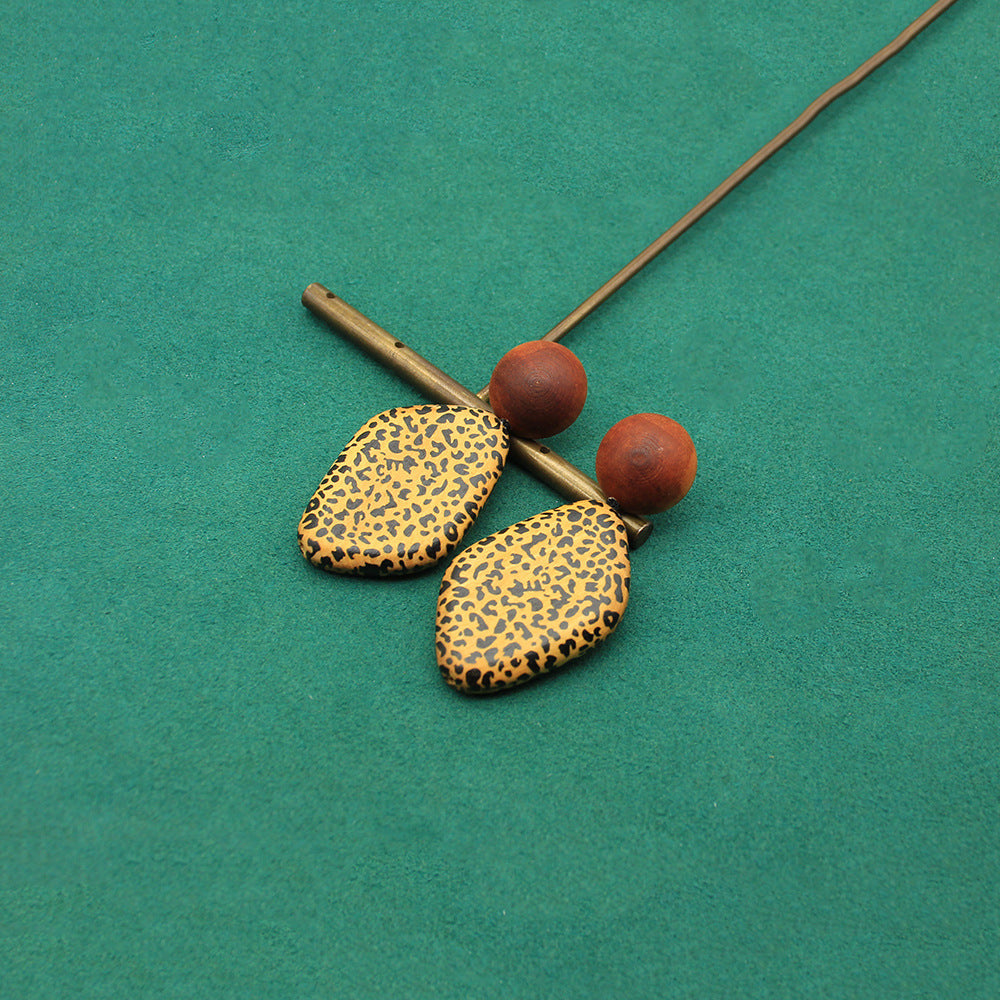 Wooden heart-shaped earrings with leopard-pattern faces and brown spherical tops