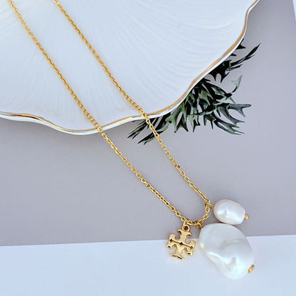 Gold necklace with two baroque pearl charms and ornate logo pendant, double-layer chain