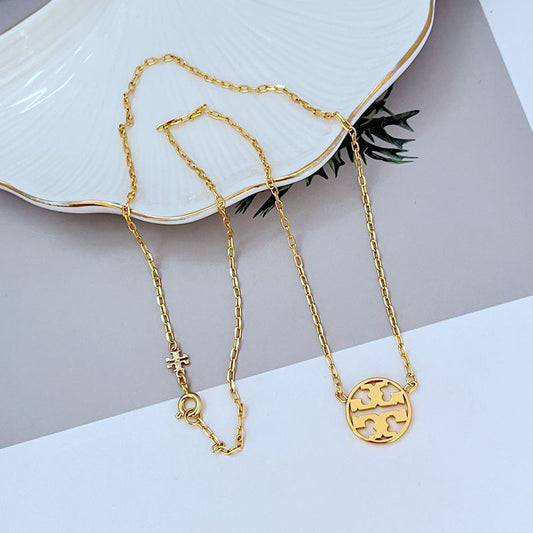 Gold metal pendant necklace with openwork round logo pendant