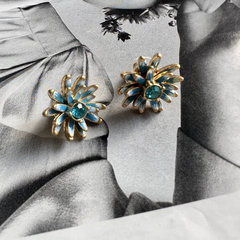 Gold enamel flower stud earrings with blue petal accents and teal center stones