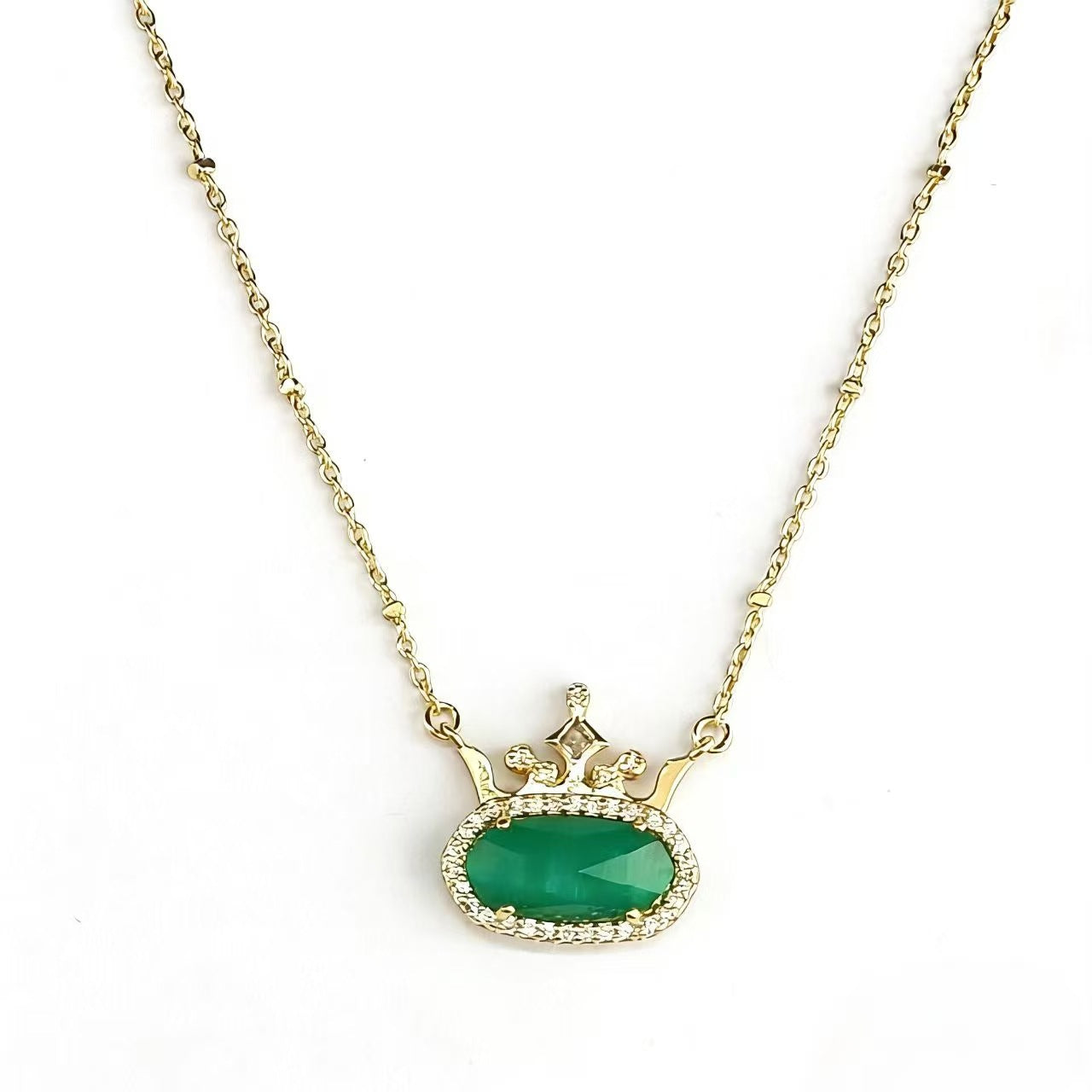 Gold-plated princess crown necklace with green oval gemstone and diamond-style halo