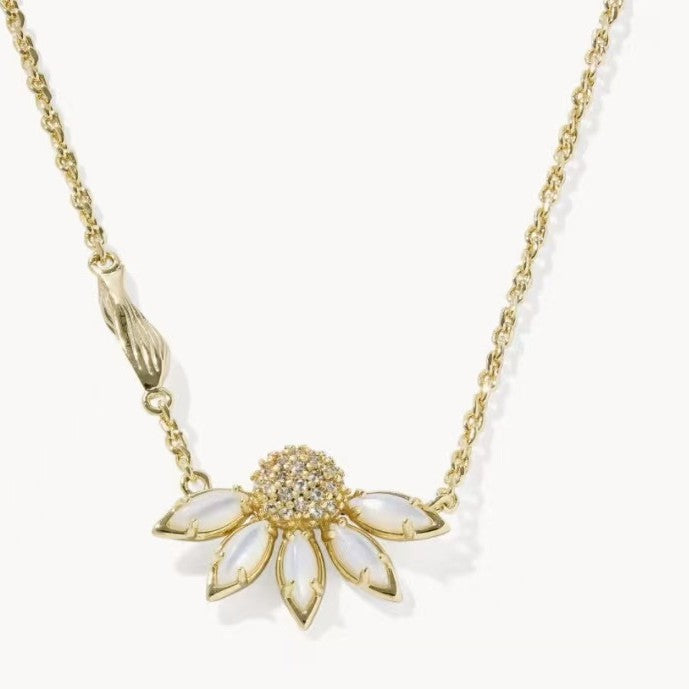 Gold-tone daisy flower pendant necklace with yellow-green rhinestone center and pale petals