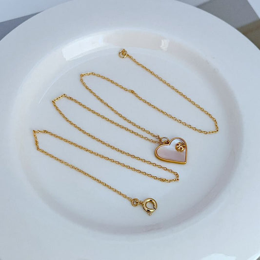 Gold heart-shaped shell pendant necklace with multiple heart charms on chains